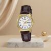 Casio ladies gold-tone watch with white Roman numeral dial, brown leather strap and day-date display